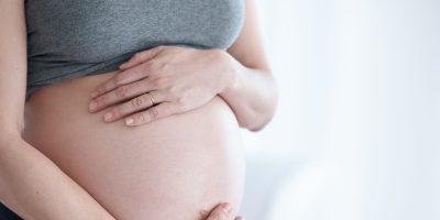 Cropped shot of a pregnant woman holding her bump