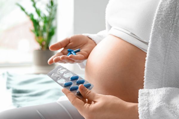 Pregnant woman holding medication